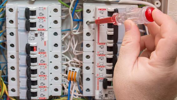 A person is working on an electrical panel.